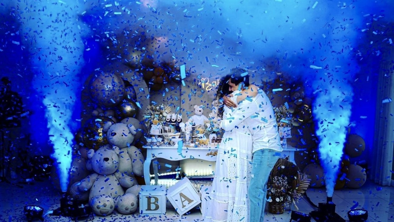 Couple avec fumée bleue lors d'un gender reveal