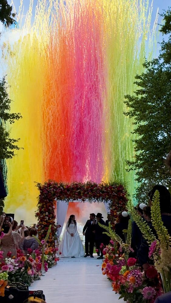 Cérémonie de mariage sous une arche décorée d'effets colorés