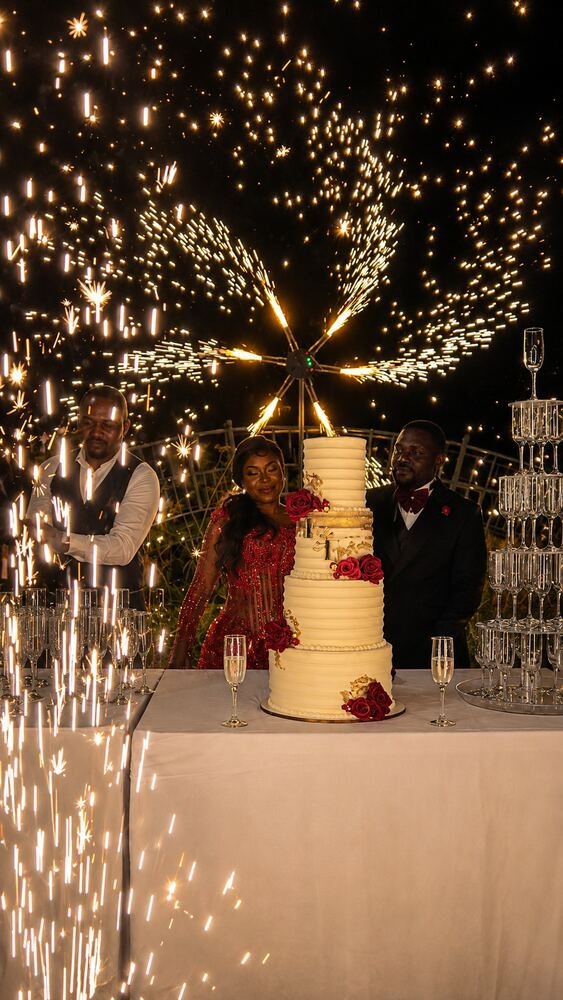 Découpe du gâteau de mariage sous des fontaines d'étincelles